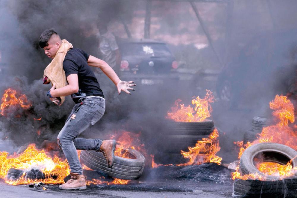 فلسطينيون خلال احتجاجات قرب نابلس بذكرى السبعين للنكبة (أ.ف.ب)