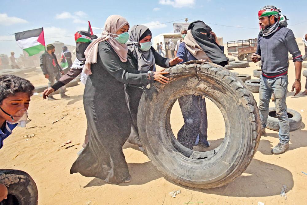 غزيات يشاركن بالمظاهرات قرب الحدود مع إسرائيل (أ.ف.ب)